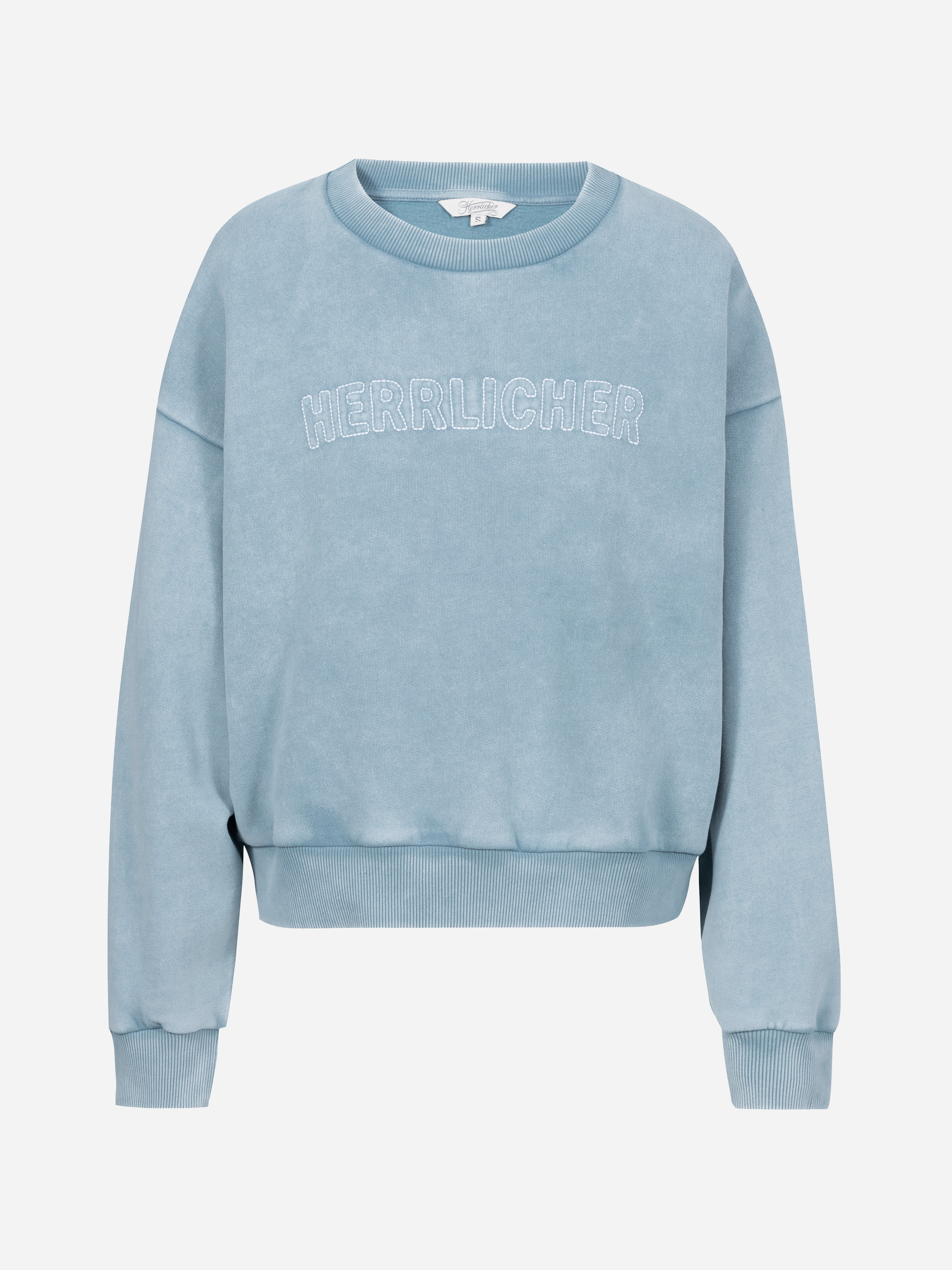 Hellblaues, langärmeliges Sweatshirt mit Rippbündchen an Ärmeln und Saum. Auf der Vorderseite ist der Schriftzug HERRLICHER in Weiß aufgestickt. Das Sweatshirt ist auf einem schlichten, weißen Hintergrund abgebildet.
