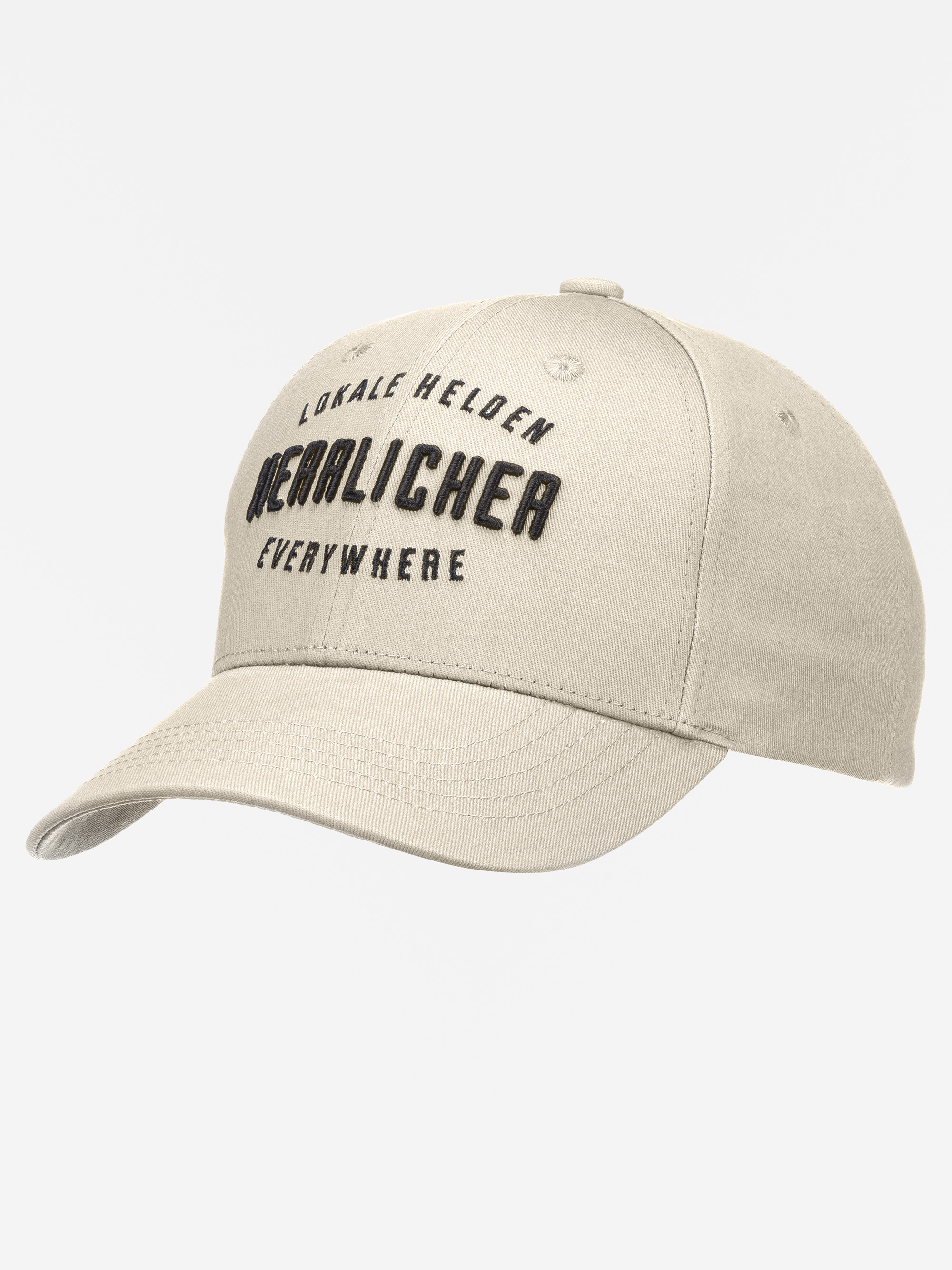 Eine beigefarbene Baseballkappe mit schwarzem gesticktem Text LOKALE HELDEN, NEULICHER und EVERYWHERE auf der Vorderseite vor einem schlichten weißen Hintergrund.