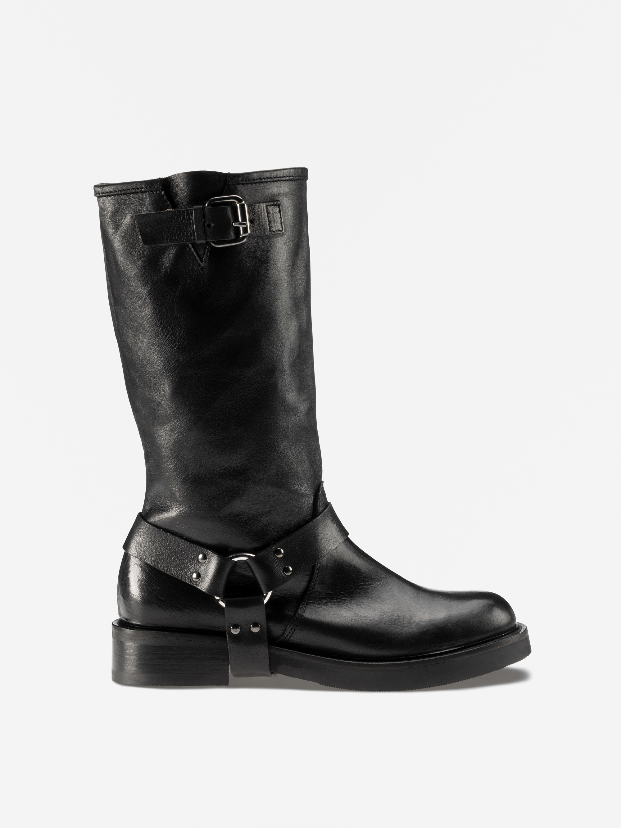 Ein schwarzer, halbhoher Lederstiefel mit niedrigem Absatz, Schnallenriemen um den Knöchel, dekorativem Metallring und einem weiteren Schnallenriemen in der Nähe des oberen Endes. Der Stiefel hat eine glatte Textur und eine robuste Sohle, die auf einem