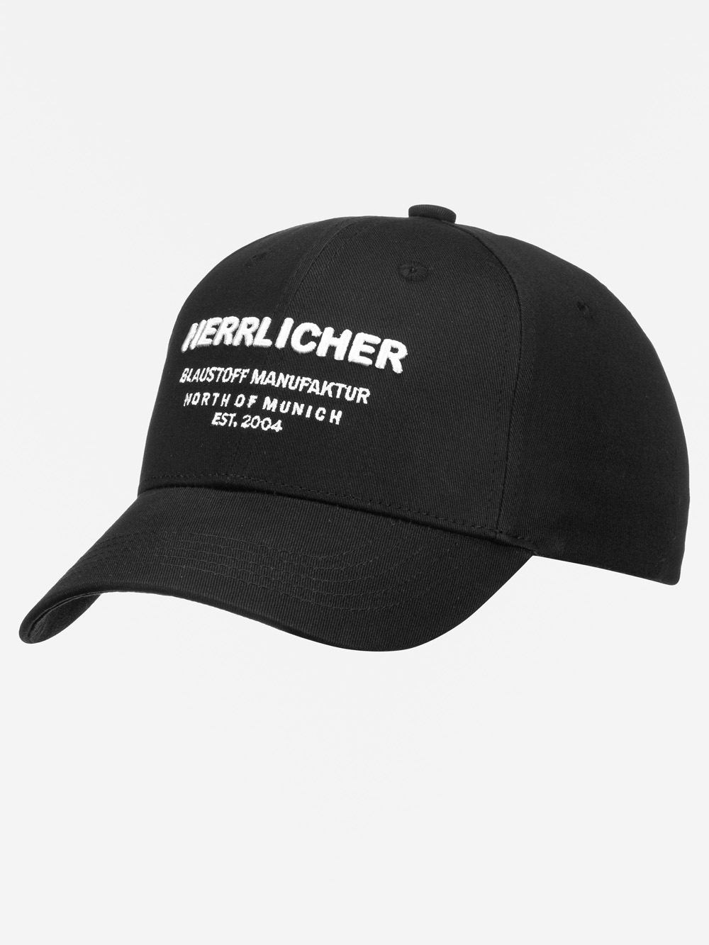 Schwarze Baseballkappe mit gebogener Krempe und weißem gesticktem Text, der lautet HERRLICHER BLAUSTOFF MANUFAKTUR NÖRDLICH VON MÜNCHEN EST. 2004.