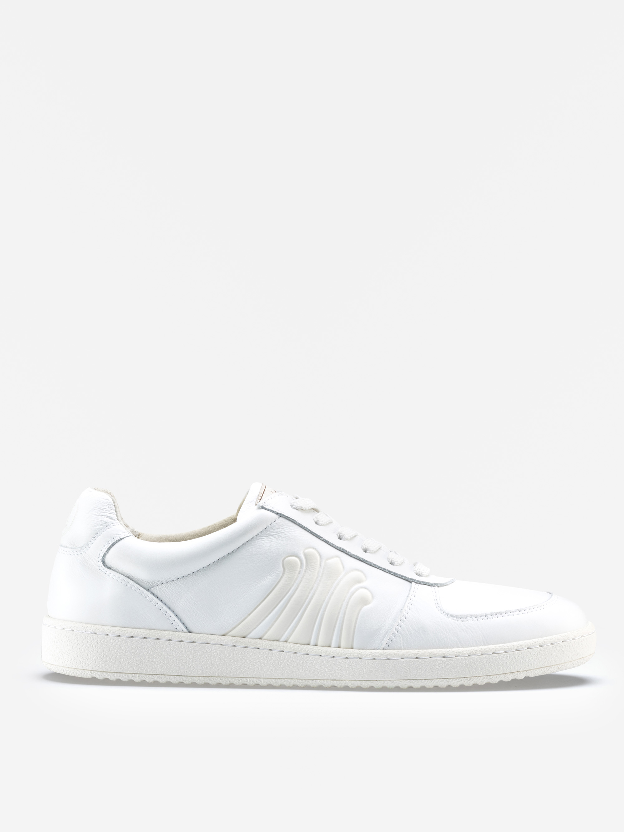 Ein weißer Ledersneaker mit weißen Schnürsenkeln, einer strukturierten weißen Sohle und einem geprägten Wellenmuster an der Seite, das vor einem schlichten weißen Hintergrund steht.