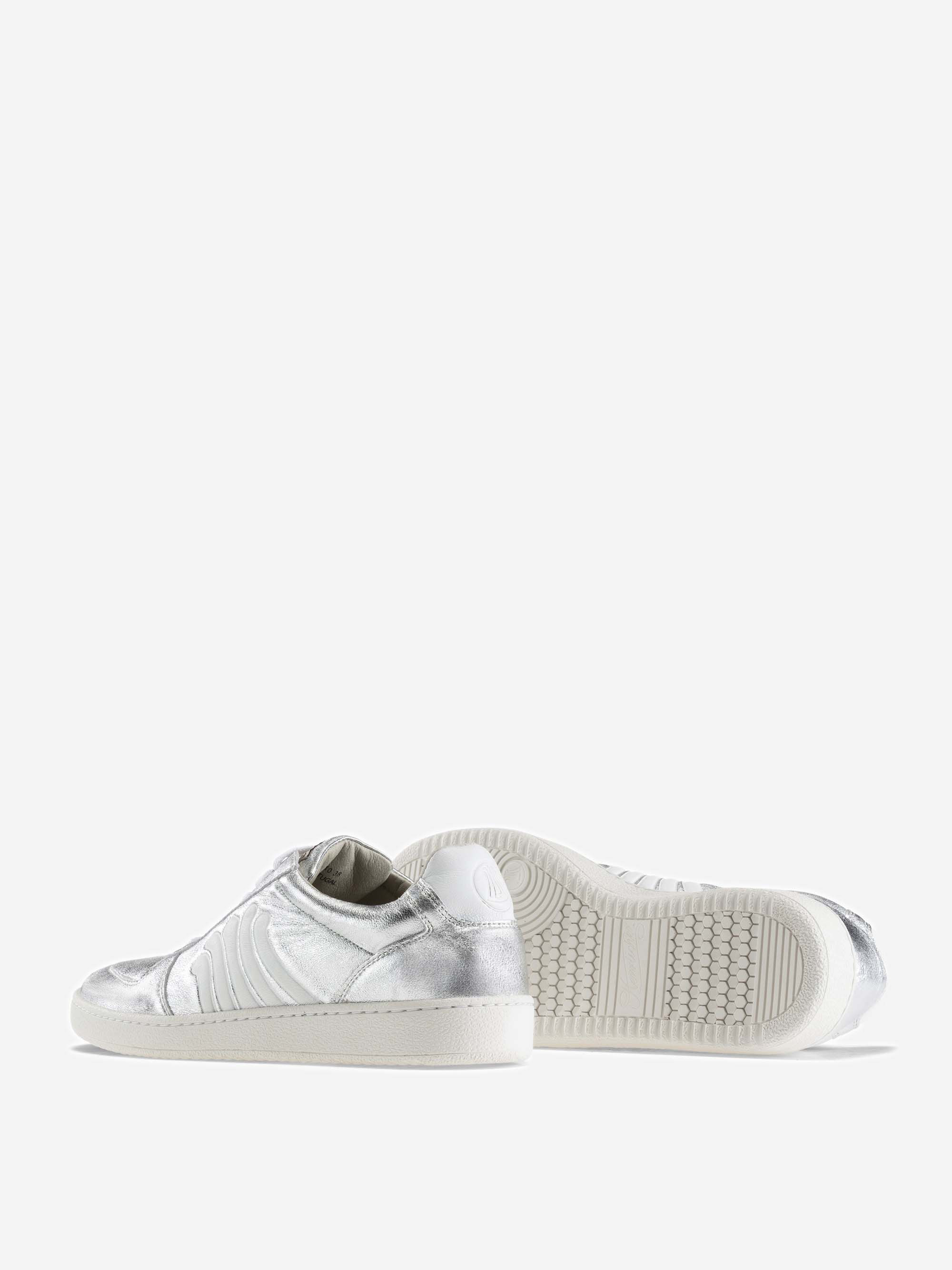 Zwei weiße Low-Top-Sneakers mit silbernen Metallic-Akzenten; ein Schuh steht aufrecht und zeigt die Seite und den Rücken, während der andere auf der Seite liegt und die Sohle und das Profil zeigt. Der Hintergrund ist hellgrau.
