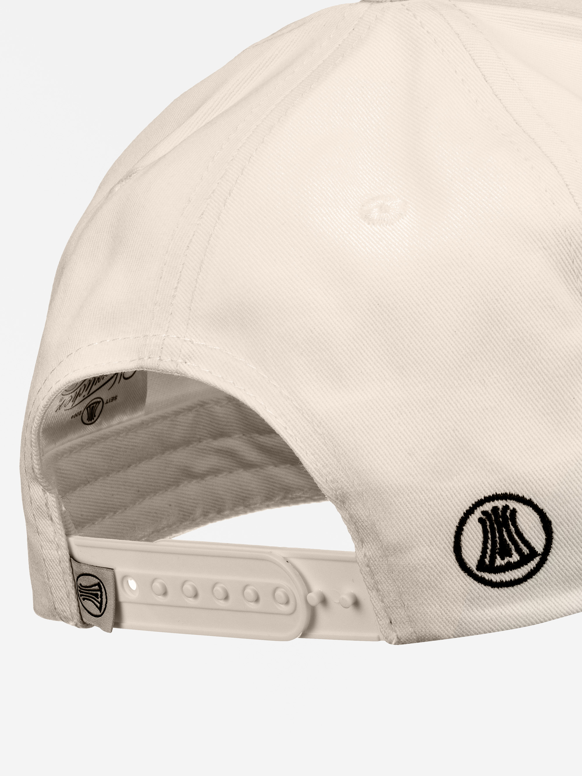 Nahaufnahme der Rückseite einer weißen Baseballmütze mit einem verstellbaren Kunststoffband und zwei schwarzen gestickten Logos in der Nähe des Bandes.