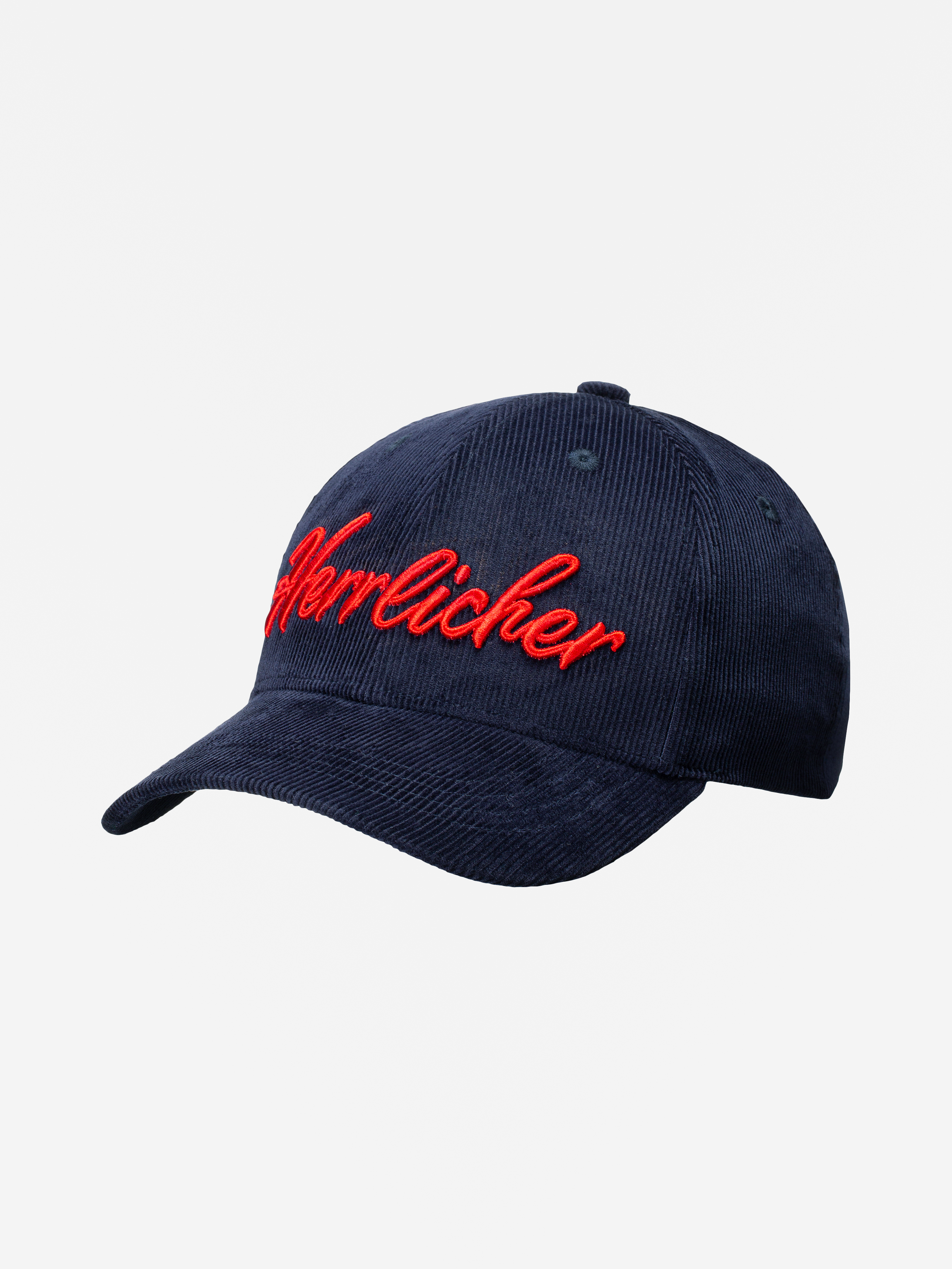 Eine marineblaue Cord-Baseballmütze mit roter kursiver Stickerei mit dem Schriftzug Herrlicher auf der Vorderseite, die auf einem schlichten weißen Hintergrund steht.
