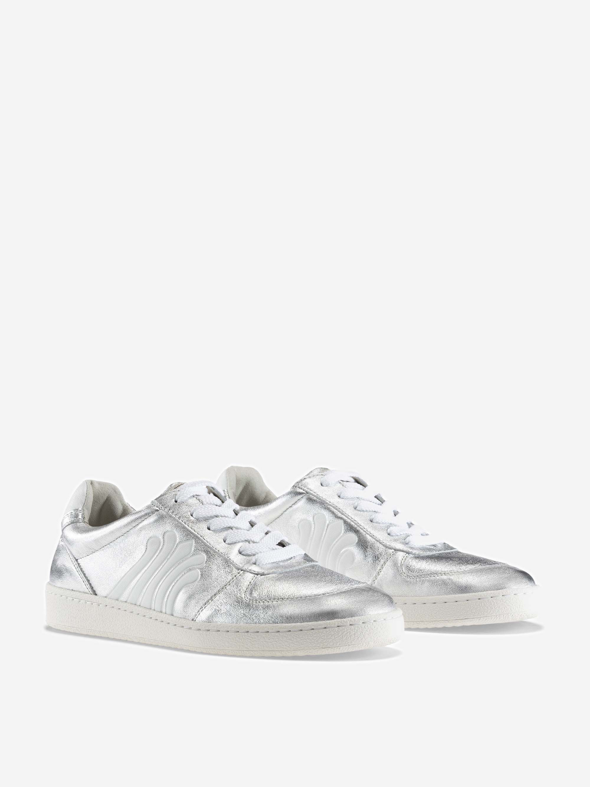 Ein Paar glänzender silberner Low-Top-Sneakers mit weißer Sohle, weißen Schnürsenkeln und einem gewellten weißen Muster an den Seiten auf einem einfarbigen hellgrauen Hintergrund.