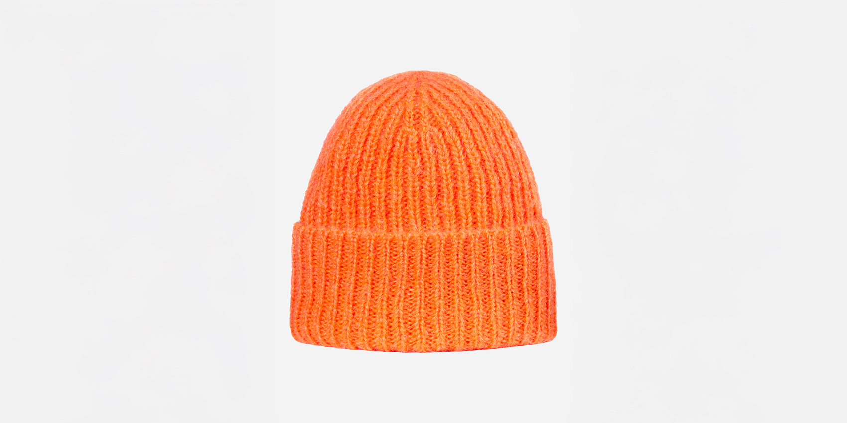 Eine leuchtend orangefarbene, gerippte Strickmütze mit umgeschlagener Krempe ist auf einem schlichten weißen Hintergrund zentriert.