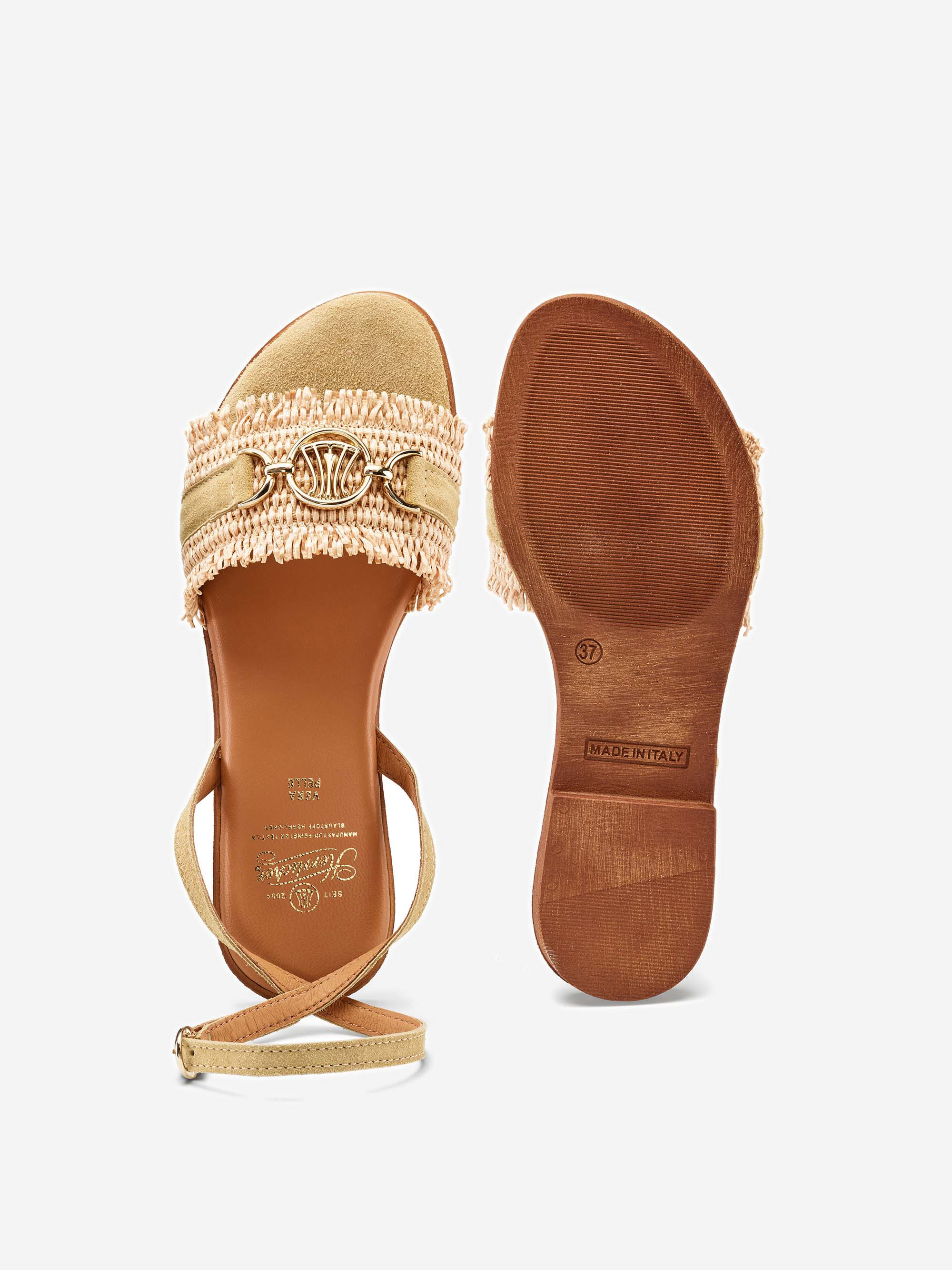 Ein Paar beigefarbene, zehenoffene Sandalen mit Knöchelriemen, goldenem Schnallendetail, gewebter Textur und ausgefransten Kanten. Eine Sandale zeigt die Draufsicht, die andere zeigt die Sohle mit MADE IN ITALY und Größe 37 Markierungen.