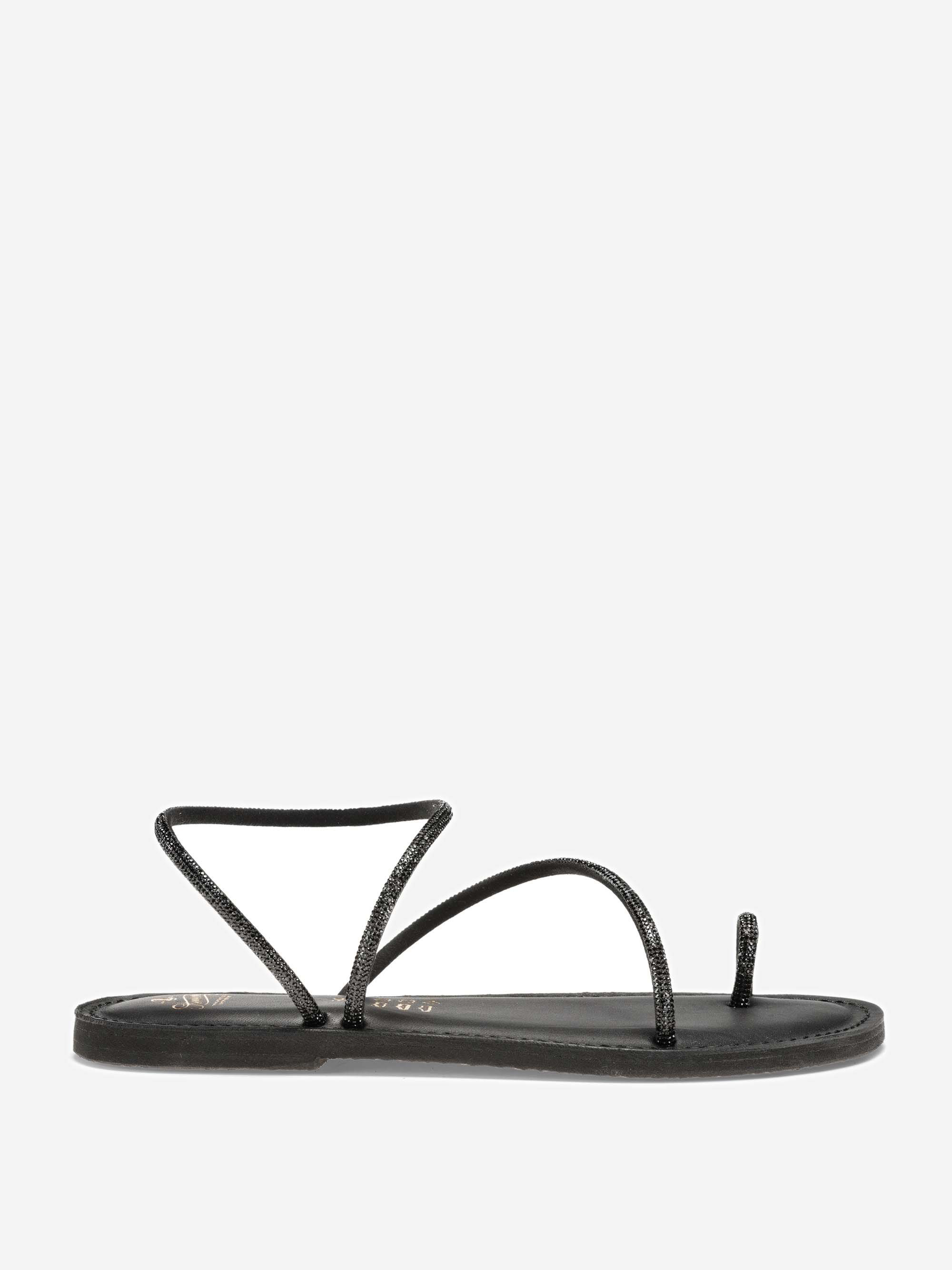 Eine minimalistische, schwarze, flache Sandale mit dünnen Riemen, einschließlich einer Zehenschlaufe und einem eckigen Riemen über dem Spann, auf einem schlichten weißen Hintergrund.