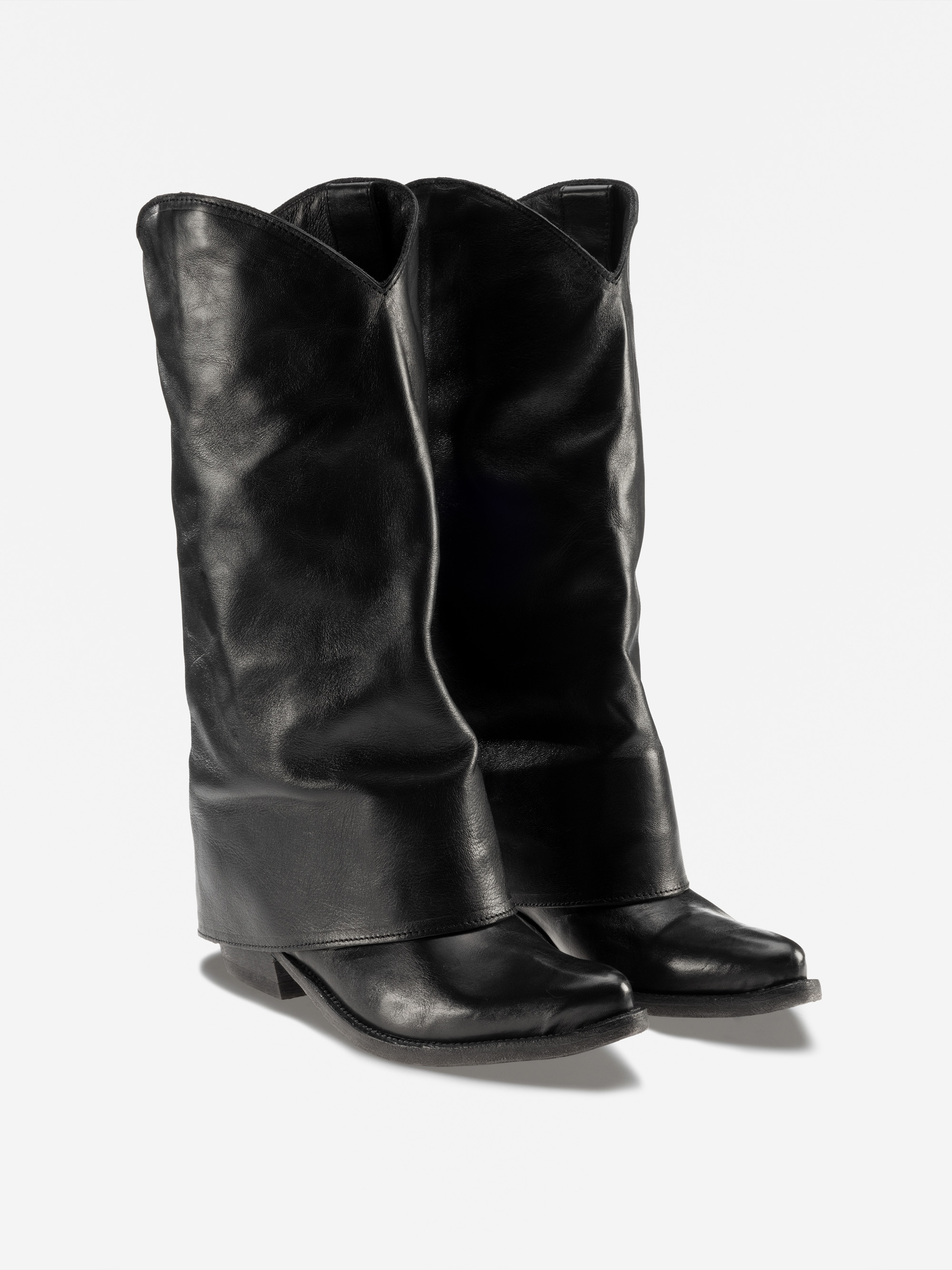 Ein Paar hohe Cowboystiefel aus schwarzem Leder mit schlabbrigem Design, spitzen Zehen und niedrigen Absätzen, die vor einem schlichten weißen Hintergrund stehen.
