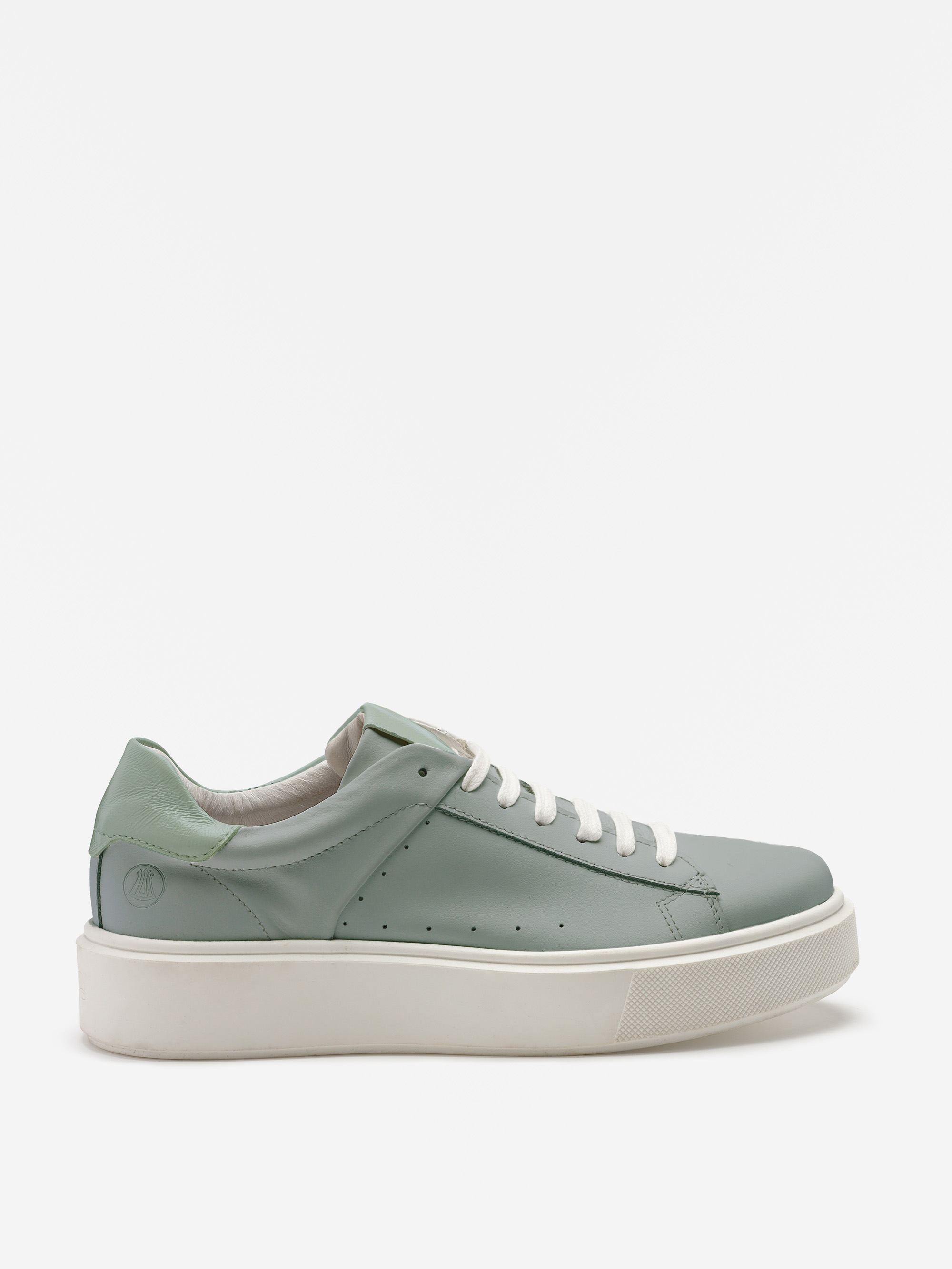 Ein hellgrüner Low-Top-Sneaker mit weißen Schnürsenkeln, perforierten Seitendetails und einer dicken weißen Sohle, dargestellt in einer seitlichen Profilansicht vor einem schlichten weißen Hintergrund.