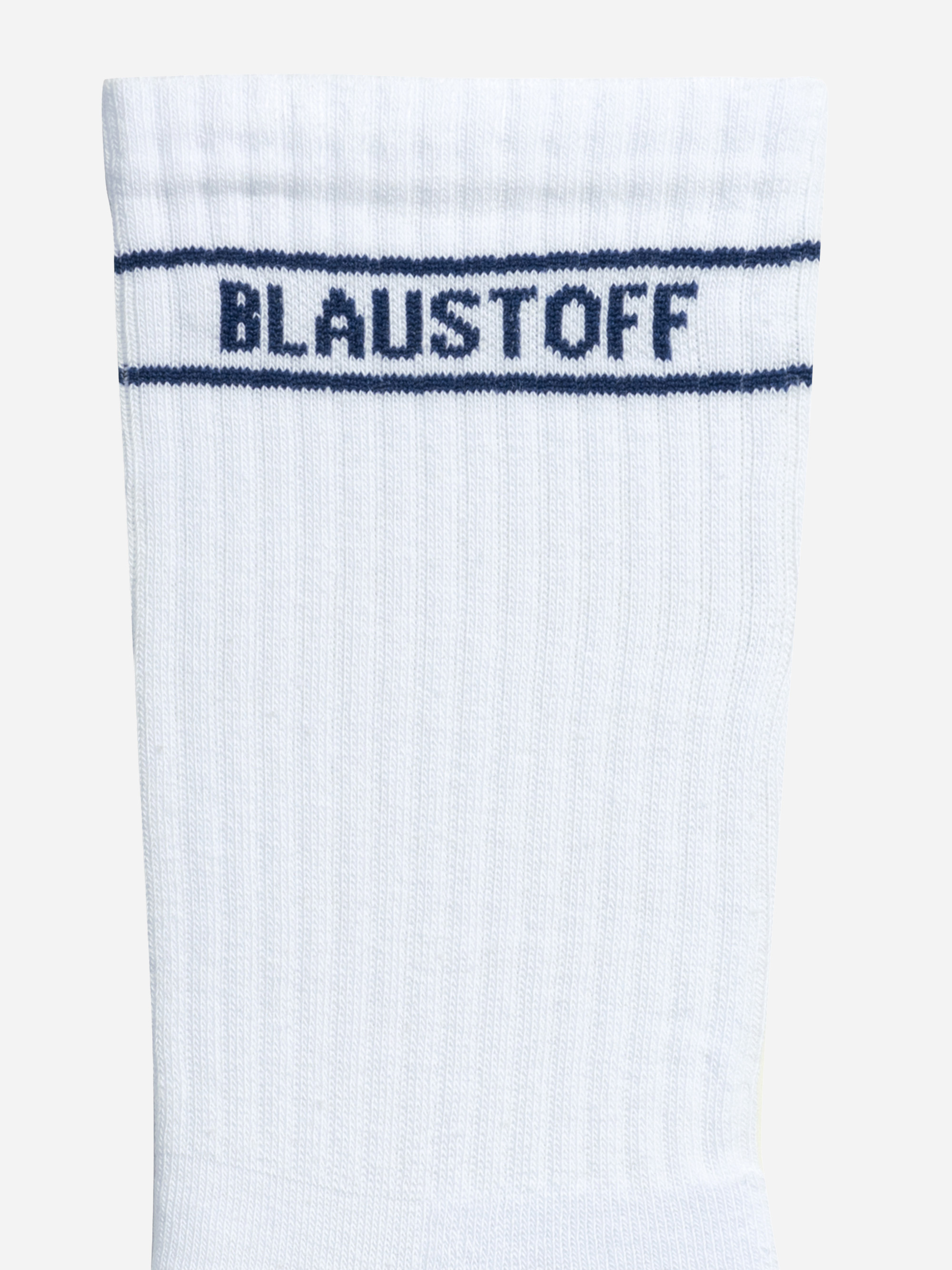 Nahaufnahme einer weißen, gerippten Socke mit zwei dünnen, horizontalen, marineblauen Streifen und dem Wort BLAUSTOFF, das in marineblau zwischen den Streifen gestrickt ist.