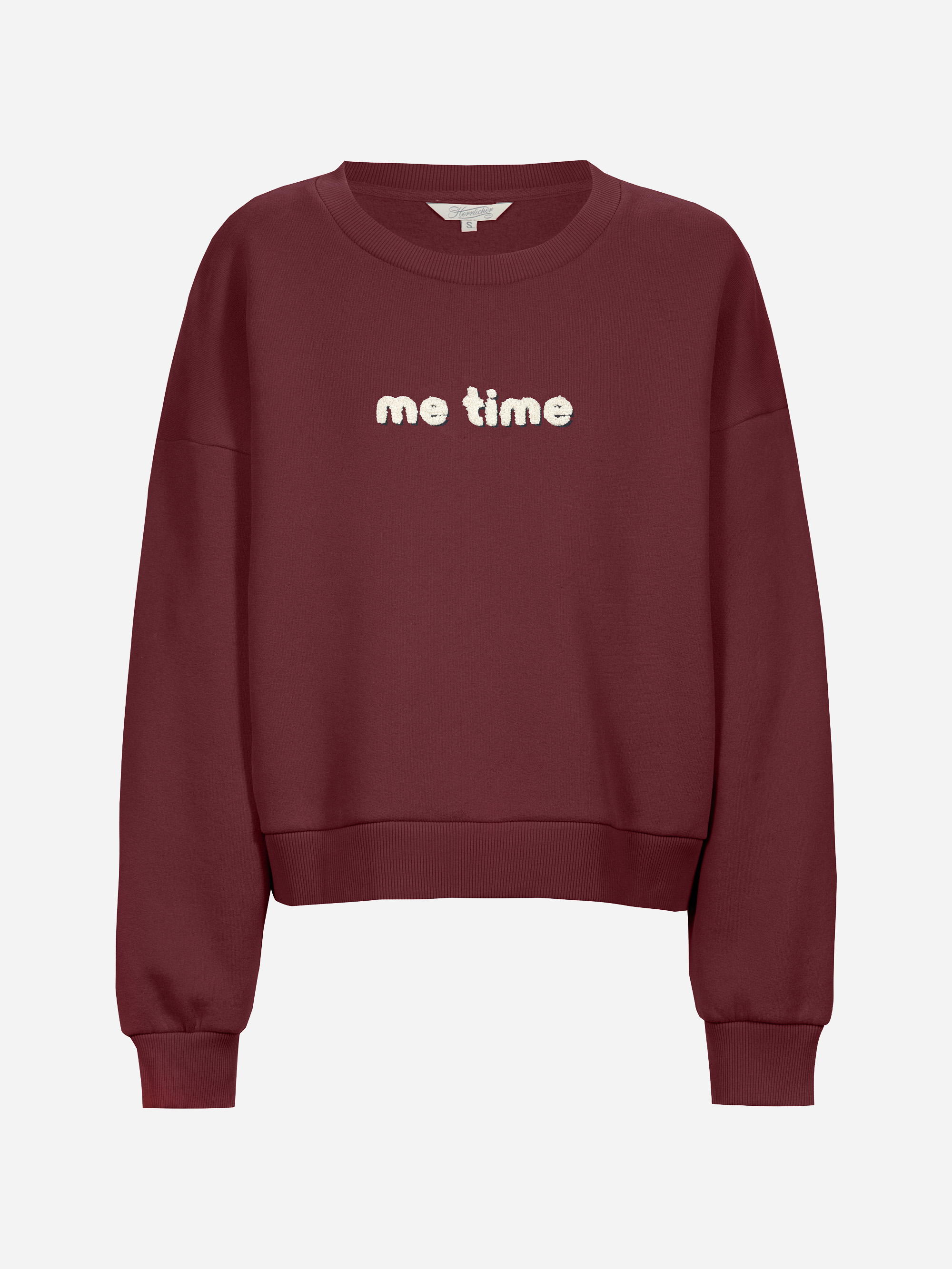 Ein kastanienbraunes Sweatshirt mit Rundhalsausschnitt, langen Ärmeln und Rippbündchen. Der Satz me time ist in weißen, flauschigen Buchstaben auf der vorderen Mitte aufgestickt. Der Hintergrund ist einfarbig weiß.