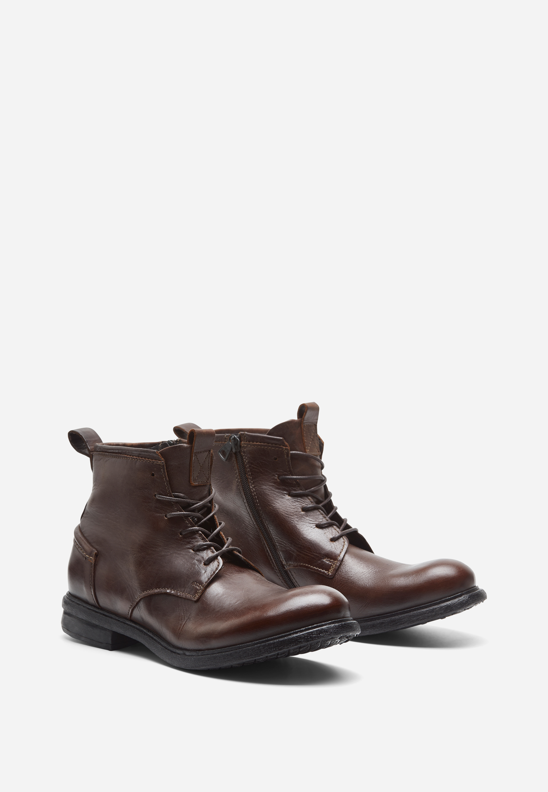 Ein Paar dunkelbraune Lederstiefel mit seitlichen Reißverschlüssen, Schnürsenkeln und niedrigen schwarzen Gummisohlen, dargestellt auf weißem Hintergrund.