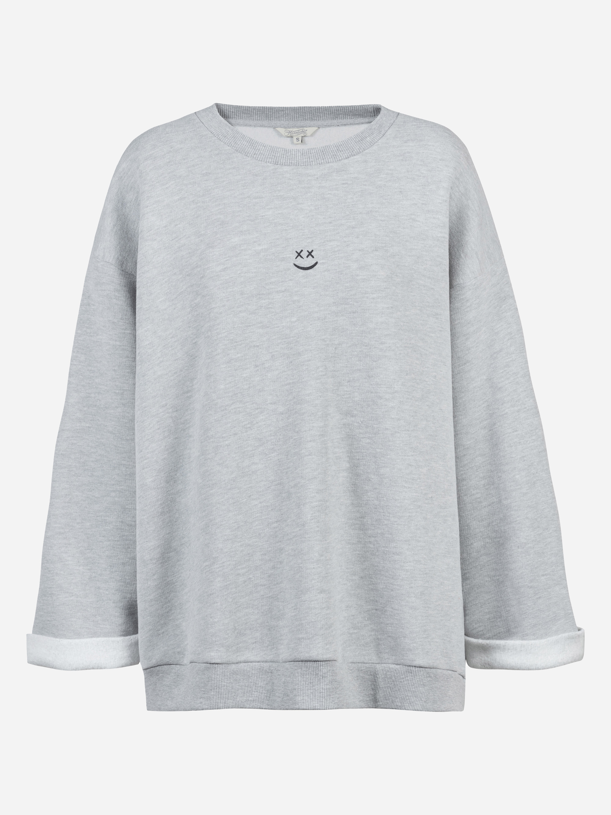 Hellgraues, langärmeliges Sweatshirt mit aufgerollten Bündchen und einem kleinen, einfach gestickten Gesicht mit X-förmigen Augen und einem geschwungenen Lächeln auf der Brust. Der Hintergrund ist einfarbig weiß.