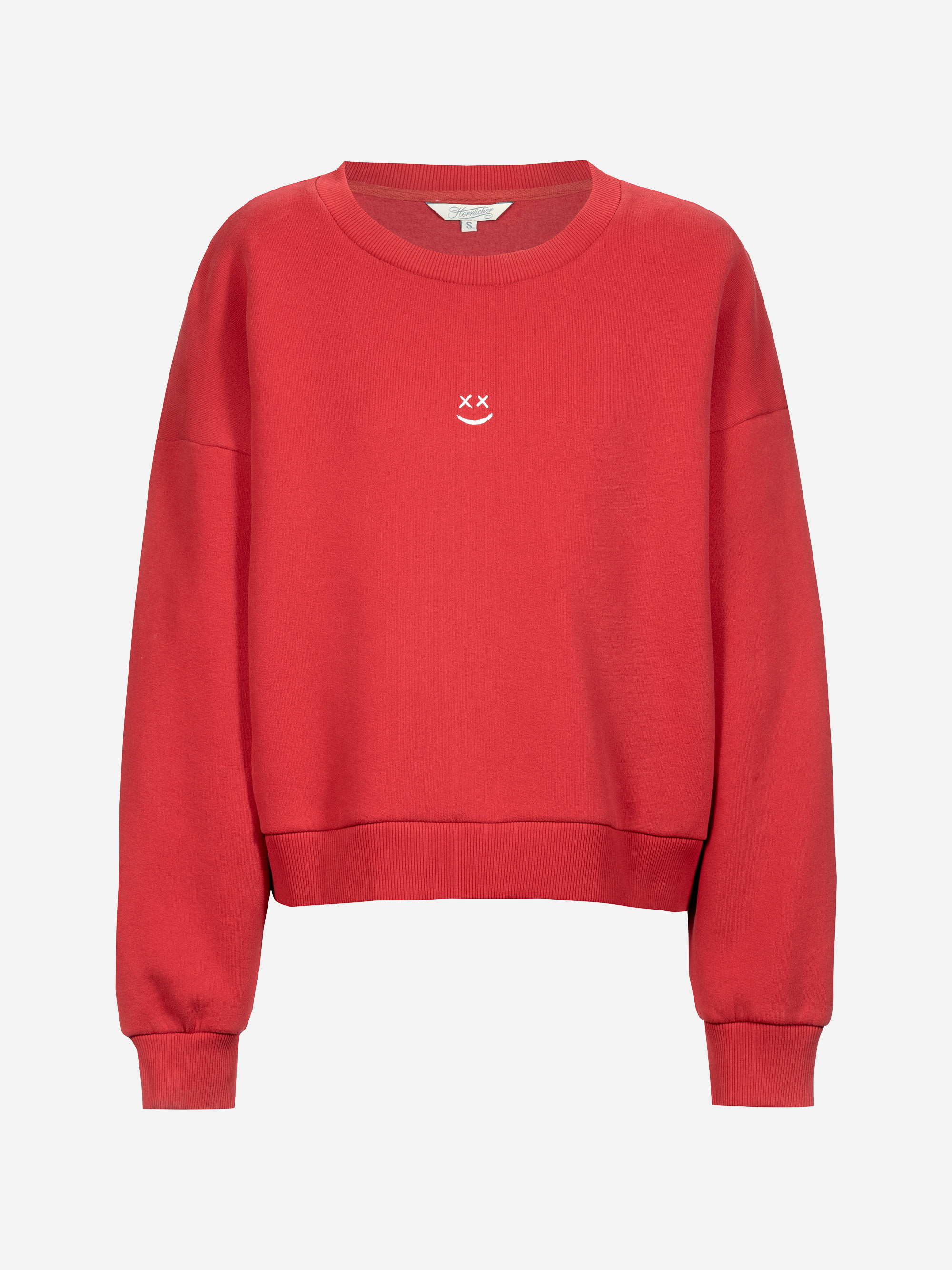 Ein schlichtes rotes Sweatshirt mit Rundhalsausschnitt und langen Ärmeln. Auf der Brust ist ein kleines weißes Gesicht mit X-förmigen Augen und einem lächelnden Mund aufgestickt.