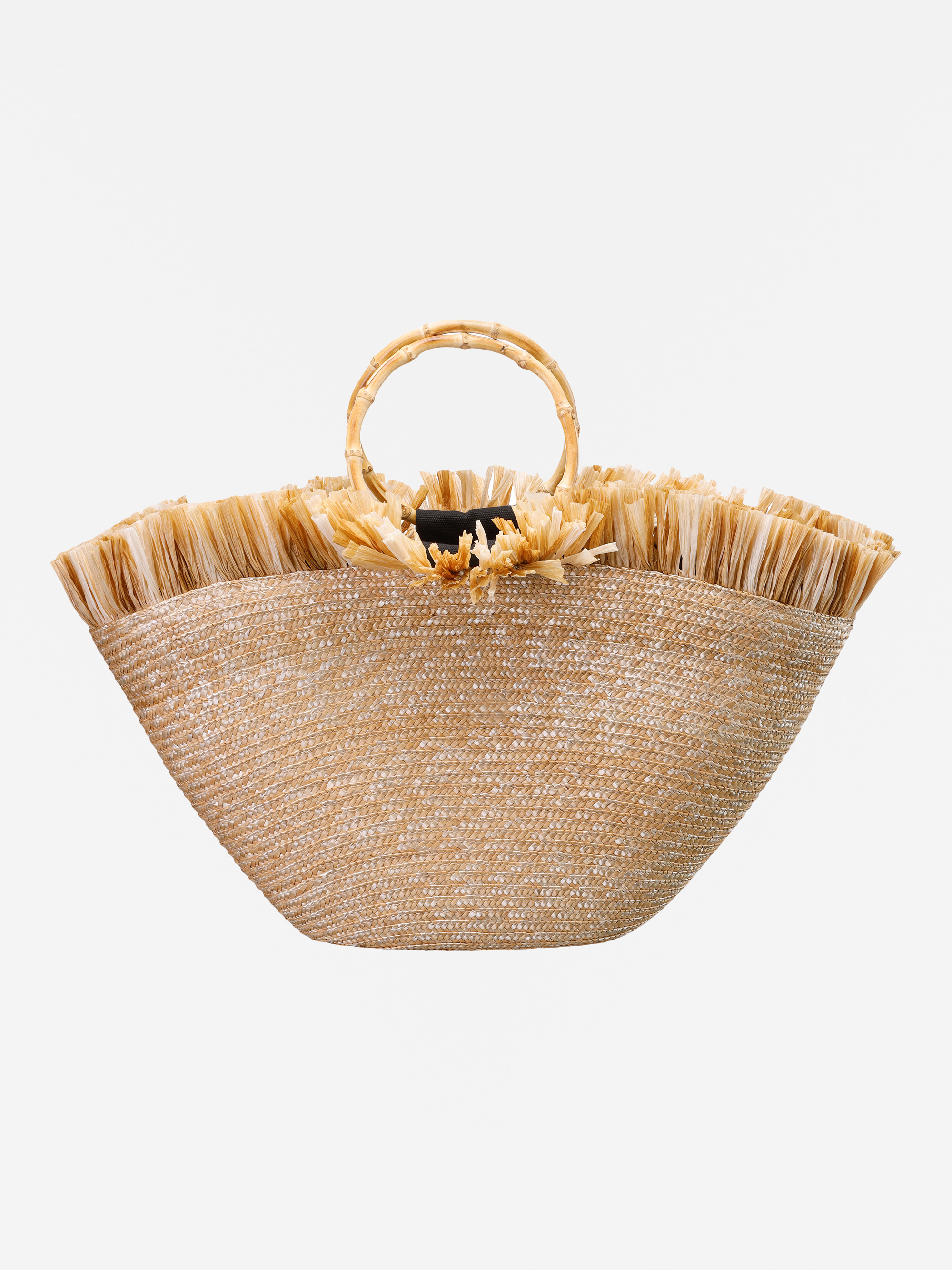 Eine geflochtene Strohhandtasche mit ausgestellter Form, ausgefransten Rändern, einem runden Bambusgriff und dekorativen Strohblumen in der Nähe des Griffs vor einem weißen Hintergrund.