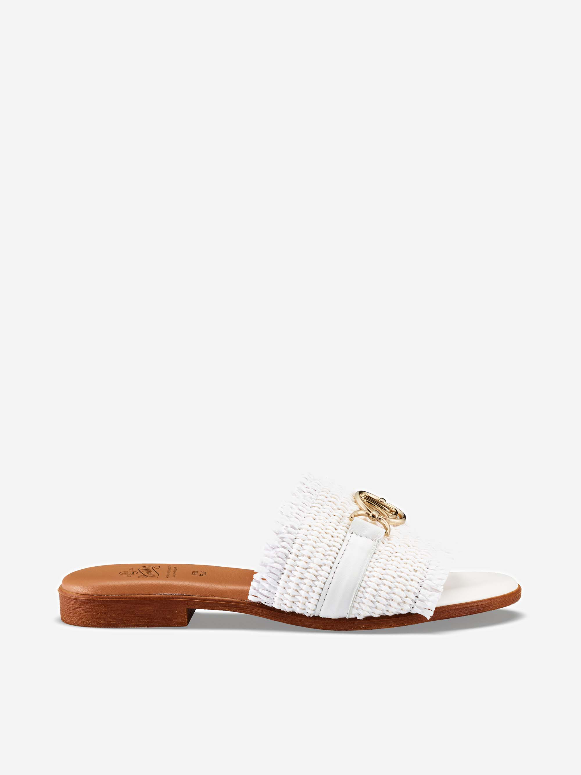 Eine weiße, gewebte Slide-Sandale mit breitem Riemen, goldener Zierkette, offener Spitze und flacher brauner Sohle vor einem schlichten hellgrauen Hintergrund.